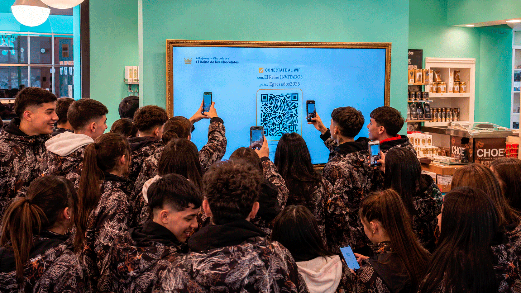 Grupo de egresados escaneando el QR del salón en la TV para entrar a la experiencia